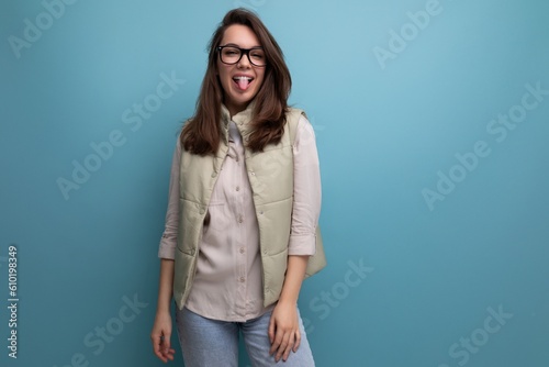 pretty young brunette woman in stylish eyeglasses on studio background with copy space