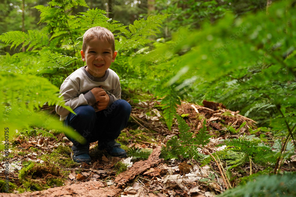 Lonely boy sitting in the woods, lost sad child. Selective focus. Lonely boy sitting in the woods, lost sad child. Selective focus.