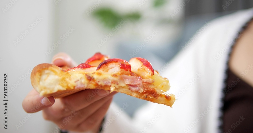 Close up hand of woman holding pizza slice. Fast food, italian kitchen and eating concept