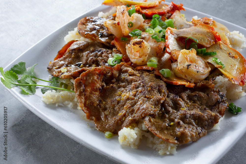 A view of a combo fried rice dish, featuring charbroiled beef, shrimp and chicken.