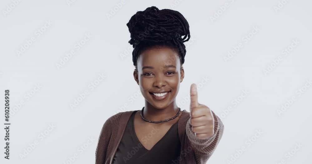 Face, smile and thumbs up of black woman in studio isolated on a white ...