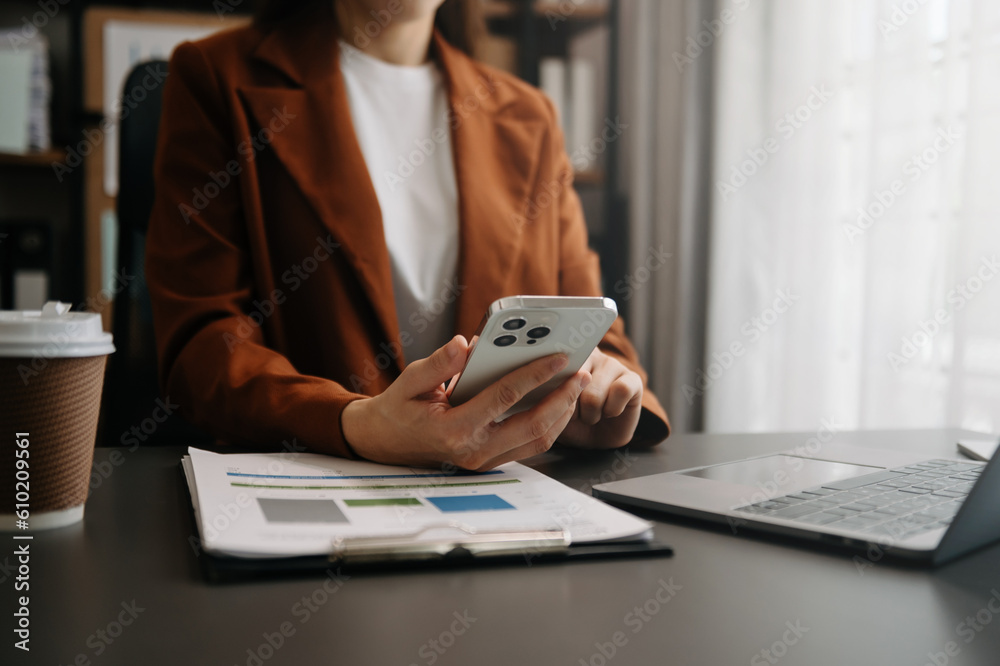 Fototapeta premium Businesswoman hand using smart phone laptop and tablet with social network diagram on desk as concept in morning light..