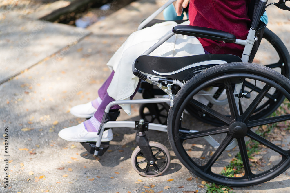 Obraz premium Nursing home. Young caregiver helping senior woman in wheelchair.