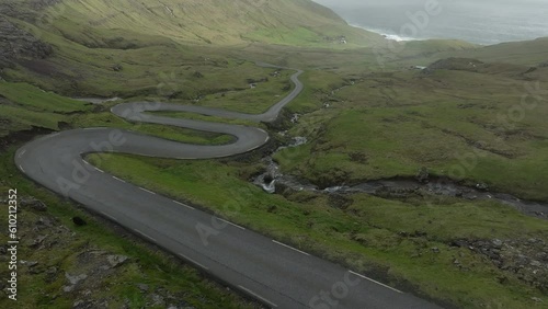 fantastic aerial shot driving along the famous winding and dangerous road that leads to Norðradalur in the Faroe Islands. photo
