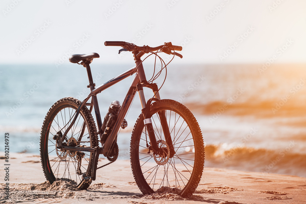 Obraz premium Bike on the Baltic Sea seashore sandy beach. Fitness sports motivation and inspiration. MTB on the seaside