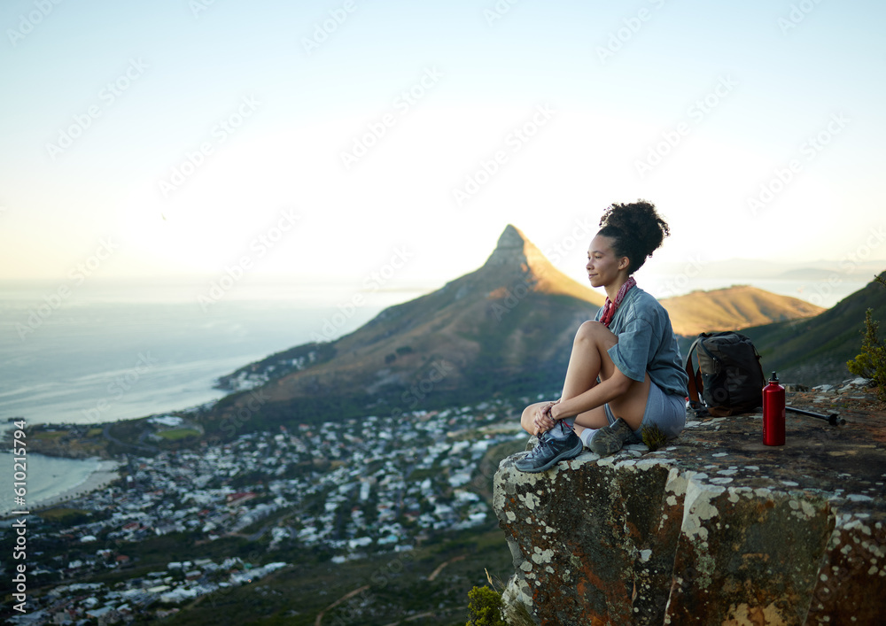 Fototapeta premium Woman, mountain and sitting with view of cityscape outdoor for exercise in Cape Town. Female hiking, cliff and South Africa for adventure in nature in the morning for wellness on the weekend.