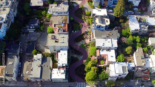 Aerial Tilt Up Shot Of Vehicles On Lombard Street Amidst Houses, Drone Flying Backward Over Neighborhood On Sunny Day - San Francisco, California