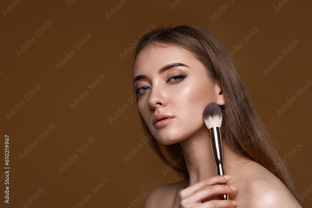 Fototapeta premium woman applying blush on cheeks with make-up brush