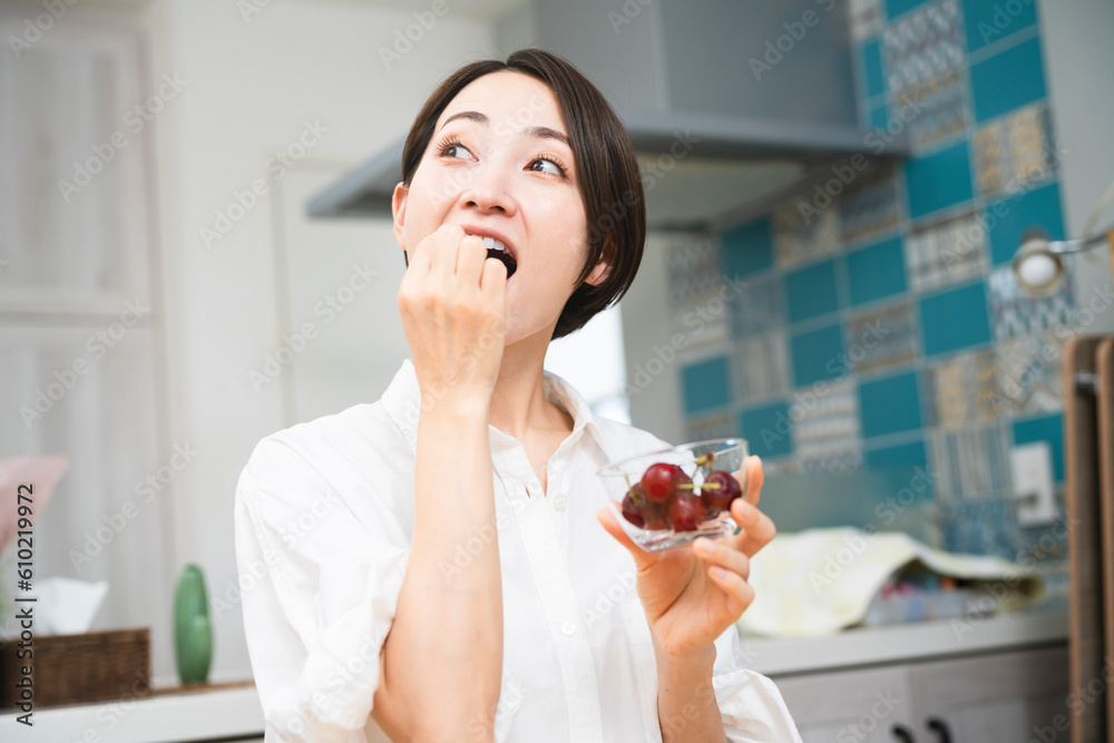 サクランボを食べる若い女性　飲食イメージ