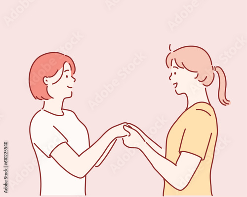 two girls holding each other by hands. Hand drawn style vector design illustrations.