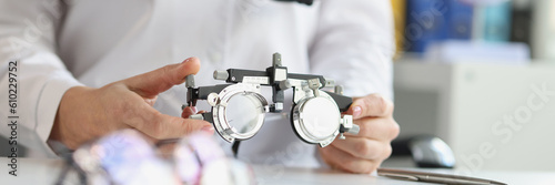Ophthalmologist with trial frame for selection of complex astigmatic glasses. Selection of lenses for glasses concept