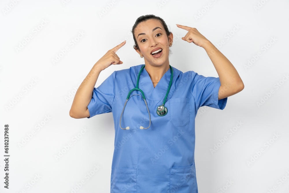Cheerful Young doctor woman wearing blue uniform over isolated background demonstrating hairdo Cheerful Young doctor woman wearing blue uniform over isolated background demonstrating hairdo