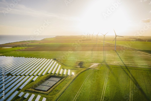 Wind turbines and solar panels farm in a field. Renewable green energy. Sunny landscape, electric energy generator for clean energy producing concept