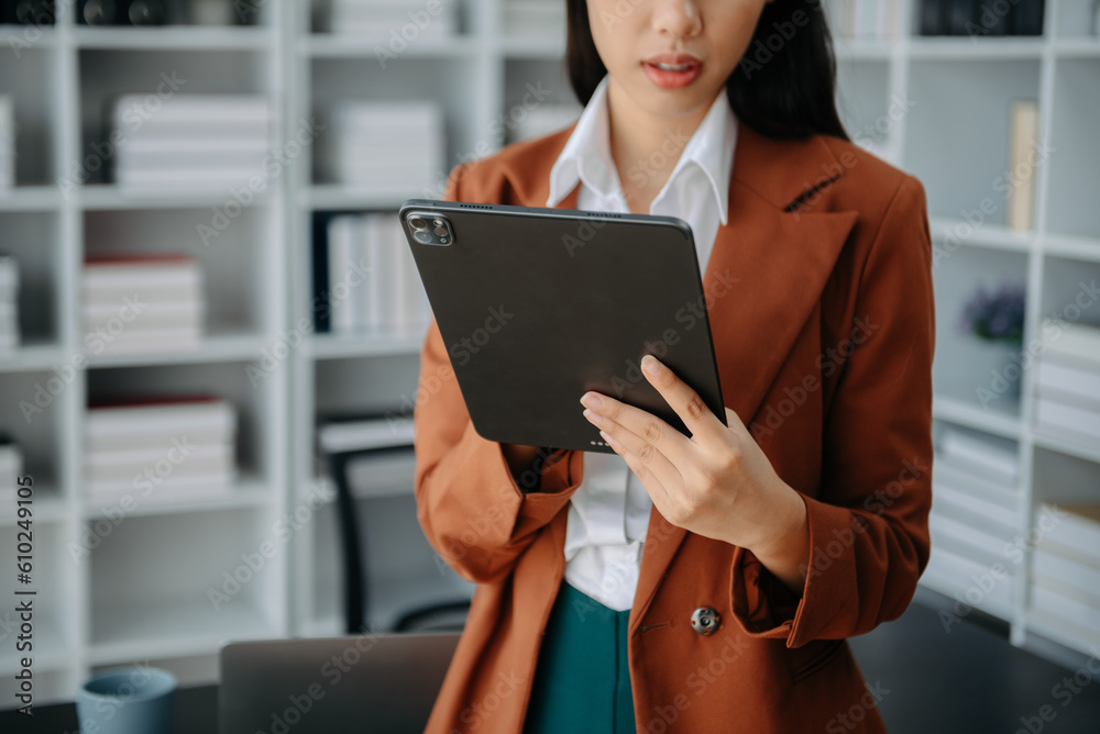 Fototapeta premium Businesswoman hand using laptop, tablet and smartphone in office. Digital marketing media mobile app and discussing plan new start up project.