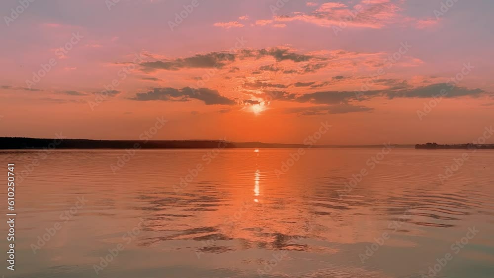 A solar eclipse during a mesmerizing fiery sunset. Majestic sunset or sunrise landscape. Sunset with reflection in the water. The sun and clouds were reflected in the water. Fiery sunset. Russia A solar eclipse during a mesmerizing fiery sunset. Majestic sunset or sunrise landscape. Sunset with reflection in the water. The sun and clouds were reflected in the water. Fiery sunset. Russia