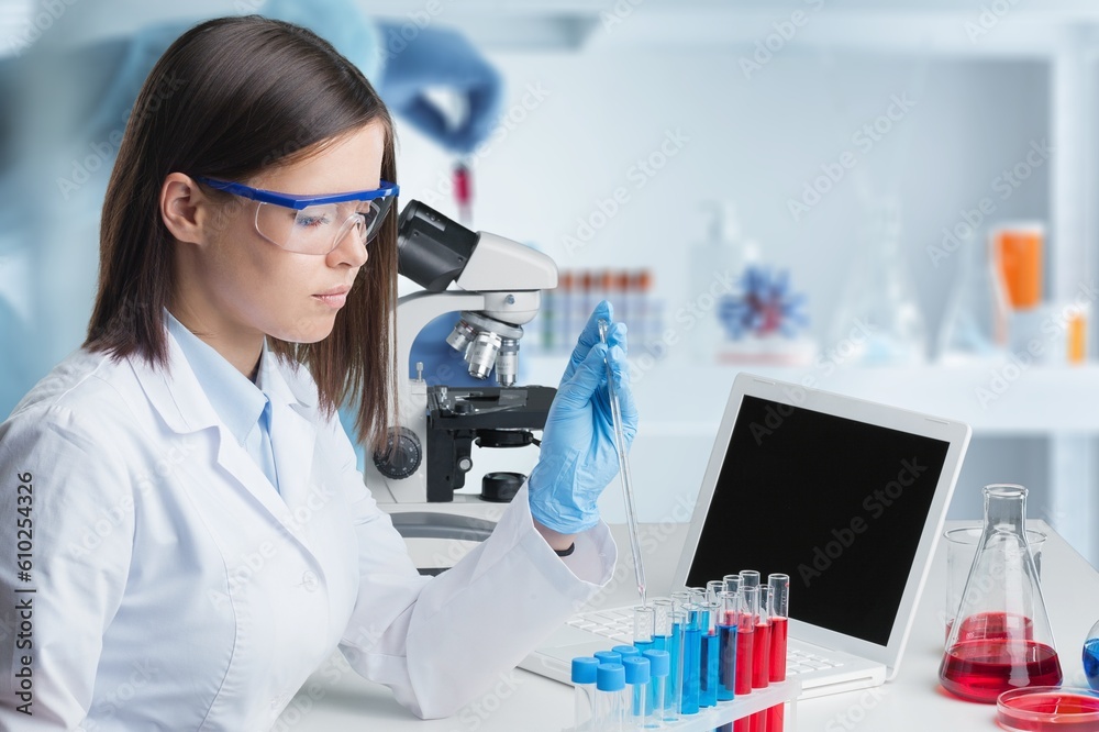 Young researcher sitting by desk in modern lab Young researcher sitting by desk in modern lab