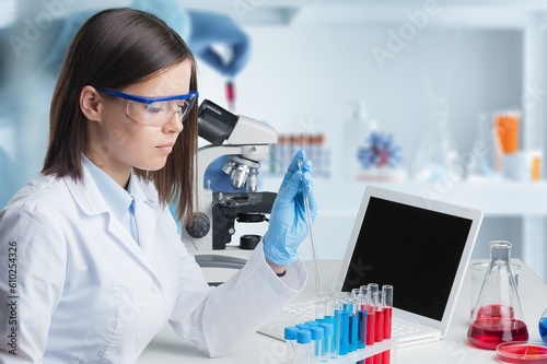 Young researcher sitting by desk in modern lab