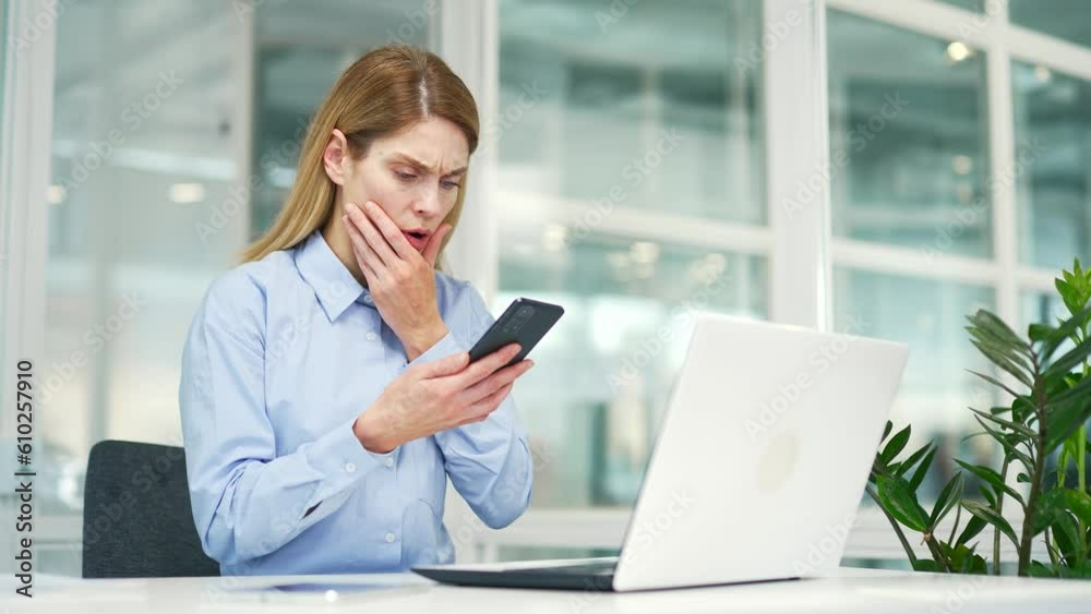 Sad disappointed mature businesswoman read bad news on smartphone while sitting at workplace at desk in modern office. Frustrated shocked female employee looking at unpleasant message or notification Sad disappointed mature businesswoman read bad news on smartphone while sitting at workplace at desk in modern office. Frustrated shocked female employee looking at unpleasant message or notification