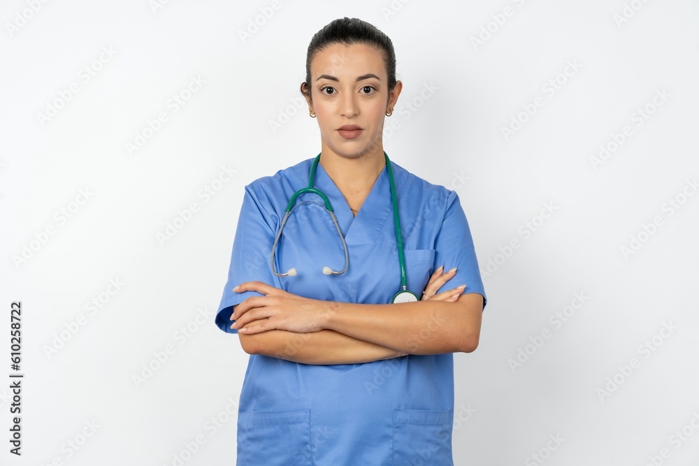 Serious pensive Beautiful doctor woman standing over white studio background feel like cool confident entrepreneur cross hands. Serious pensive Beautiful doctor woman standing over white studio background feel like cool confident entrepreneur cross hands.