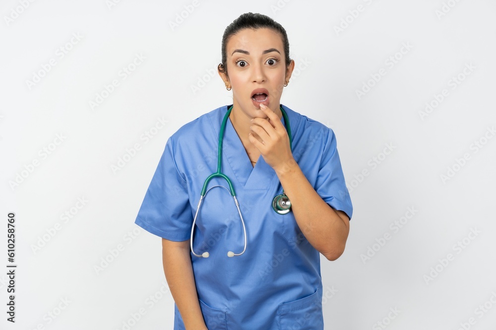 Nervous puzzled Beautiful doctor woman standing over white studio background opens mouth from surprise, reacts on sudden news. Nervous puzzled Beautiful doctor woman standing over white studio background opens mouth from surprise, reacts on sudden news.