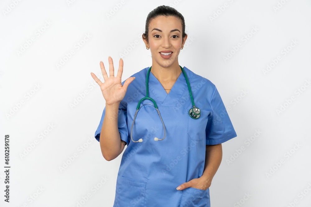 Beautiful doctor woman standing over white studio background showing and pointing up with fingers number five while smiling confident and happy. Beautiful doctor woman standing over white studio background showing and pointing up with fingers number five while smiling confident and happy.