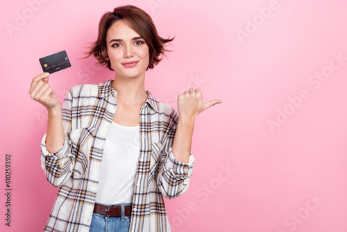 Photo of pretty girl hand hold plastic debit card indicate finger empty space isolated on pink color background