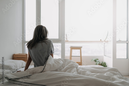 Back of asian woman just wake up and looking at the view in the morning.