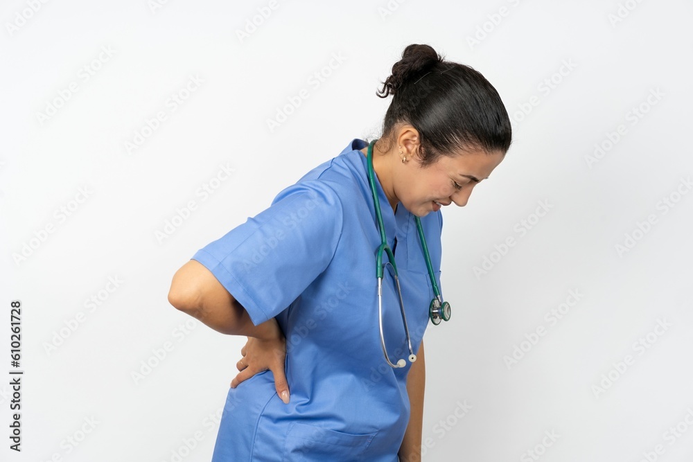 Beautiful doctor woman standing over white studio background Suffering of backache, touching back with hand, muscular pain Beautiful doctor woman standing over white studio background Suffering of backache, touching back with hand, muscular pain