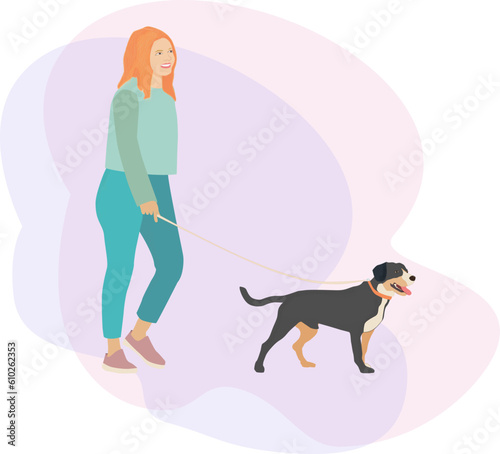 girl walks with a smile and leads a dog of the Entlebucher Sennenhund breed on a leash. The concept of friendship and love for animals