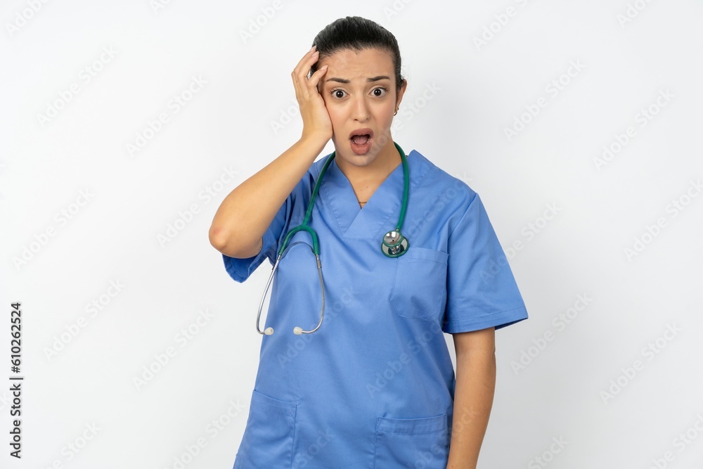 Embarrassed Beautiful doctor woman standing over white studio background with shocked expression, expresses great amazement, Puzzled model poses indoor Embarrassed Beautiful doctor woman standing over white studio background with shocked expression, expresses great amazement, Puzzled model poses indoor
