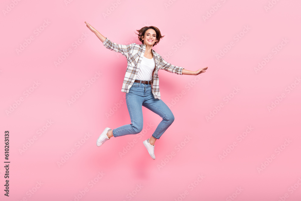 Full body photo of lovely cheerful lady jumping have good mood isolated on pink color background