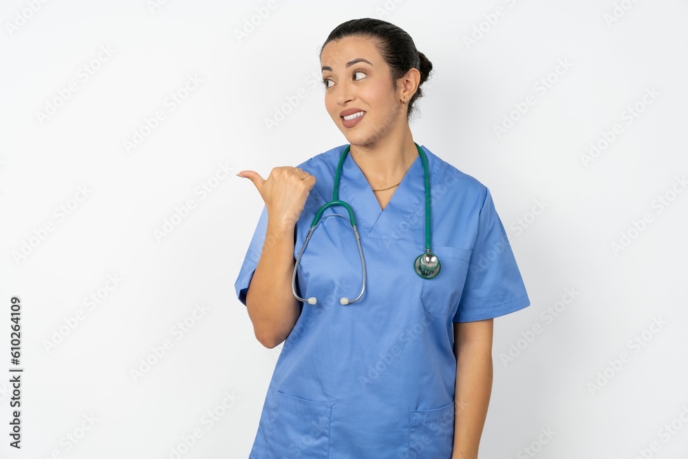 Beautiful doctor woman standing over white studio background points away and gives advice demonstrates advertisement Beautiful doctor woman standing over white studio background points away and gives advice demonstrates advertisement