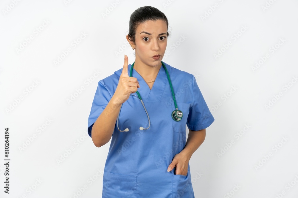 Beautiful doctor woman standing over white studio background frustrated and pointing to the front Beautiful doctor woman standing over white studio background frustrated and pointing to the front