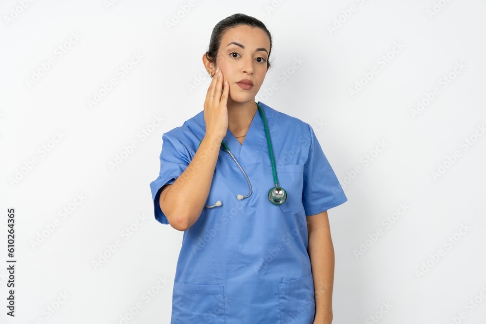 Photo of Beautiful doctor woman standing over white studio background enjoy fresh perfect smooth skin touch face Photo of Beautiful doctor woman standing over white studio background enjoy fresh perfect smooth skin touch face