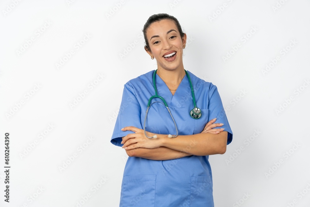 Portrait of charming Beautiful doctor woman standing over white studio background standing confidently smiling toothily with hands folded Portrait of charming Beautiful doctor woman standing over white studio background standing confidently smiling toothily with hands folded