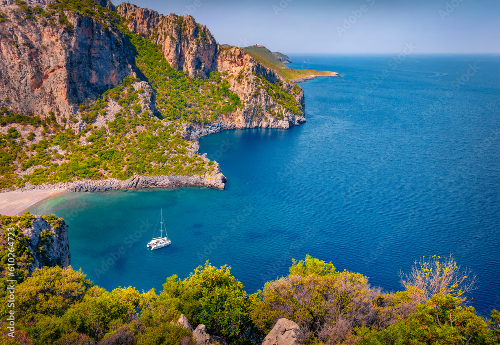 Obraz premium Marvelous view of Damos Beach with luxury yacht in the bay. Superb summer scene of Peloponnese peninsula, Greece, Europe. Nice morning seascape of Myrtoan Sea. Vacation concept background.