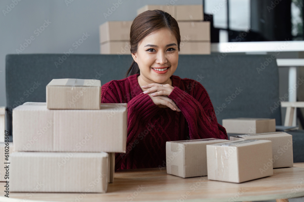 Woman owner of a startup company selling products online on an online store, sending goods through a courier company, Business planning. Online selling and online shopping concepts Woman owner of a startup company selling products online on an online store, sending goods through a courier company, Business planning. Online selling and online shopping concepts