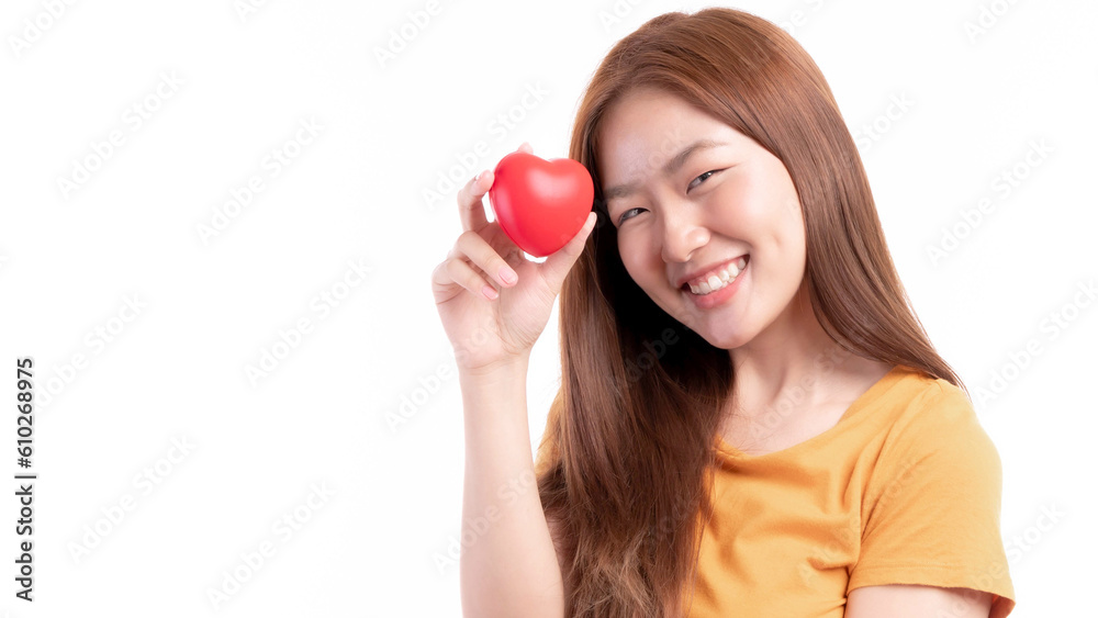 Portrait of smiling a beautiful Asian young woman holding red heart in hand on white background- Valentine day concept Portrait of smiling a beautiful Asian young woman holding red heart in hand on white background- Valentine day concept
