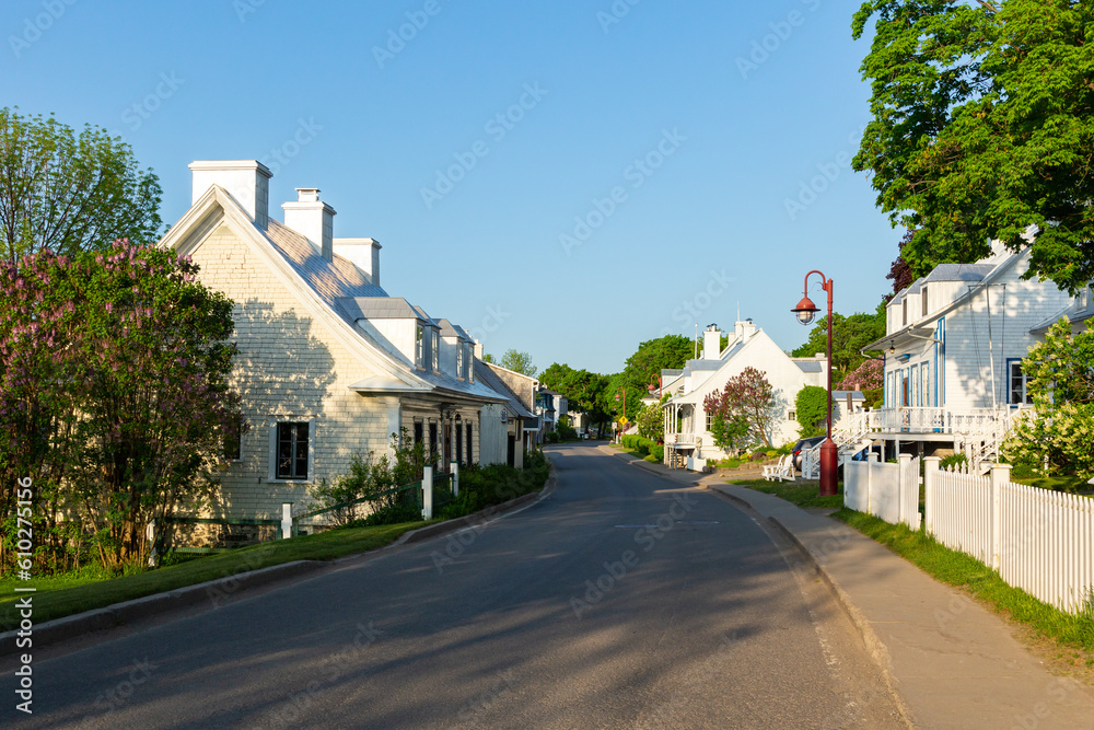 Fototapeta premium Series of old mid-19th century houses along the Chemin Royal in the quaint village of St-Jean in the spring, Island of Orleans, Quebec, Canada