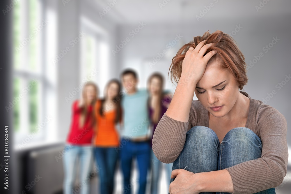 Young woman feels upset with friends on background Young woman feels upset with friends on background