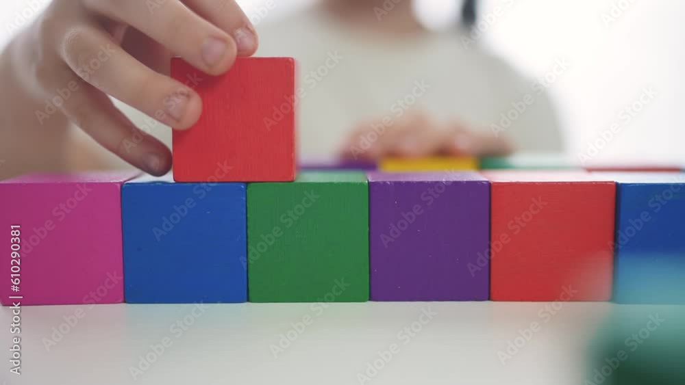 child girl in kindergarten play with blocks on the table by the window fun. education development children game concept. child kid play with blocks at home rejoice having. child play cube at home child girl in kindergarten play with blocks on the table by the window fun. education development children game concept. child kid play with blocks at home rejoice having. child play cube at home
