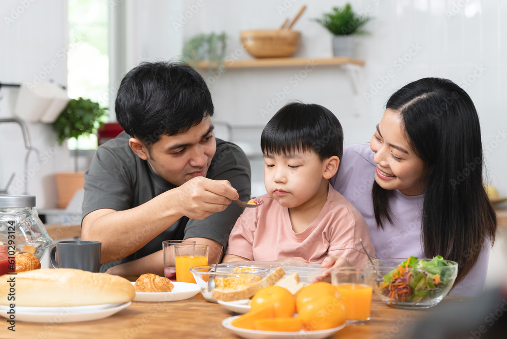 happy family together. Asian parent eating breakfast with little son in the kitchen. happy family together. Asian parent eating breakfast with little son in the kitchen.