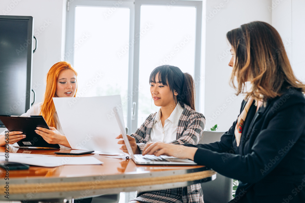 three serious diverse businesswomen discussing business project working together in office, focused management colleagues exchanging ideas. three serious diverse businesswomen discussing business project working together in office, focused management colleagues exchanging ideas.