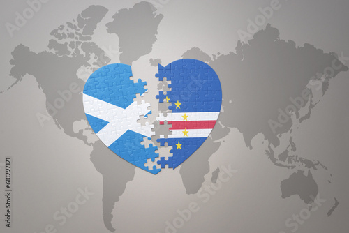 puzzle heart with the national flag of cape verde and scotland on a world map background.Concept.