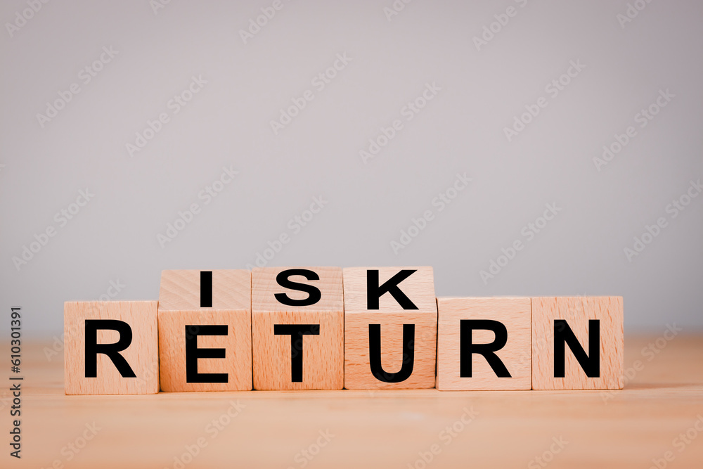 Obraz premium Investment concept about balance between risk and return with Flipping of wooden cubes block which print screen risk and return wording.