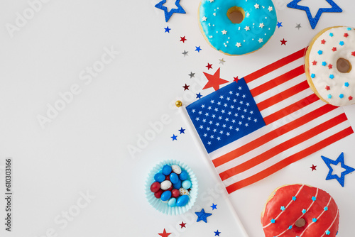 The idea of sweet celebration American Independence Day. Top view flat lay of national flag, red, blue, white donuts, delicious candies, confetti on white background with space for ad or text