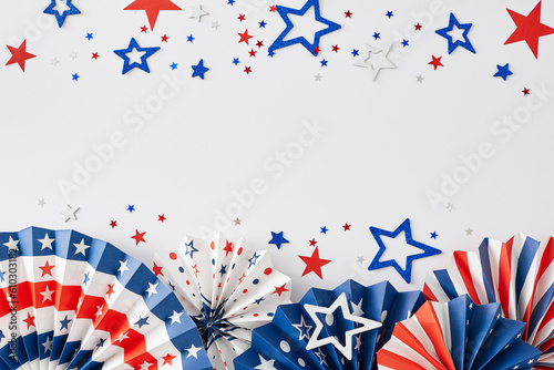Party concept for celebrating American Independence Day. Top view flat lay of patriotic paper decorations, star-shaped confetti on white background with empty space for message or text