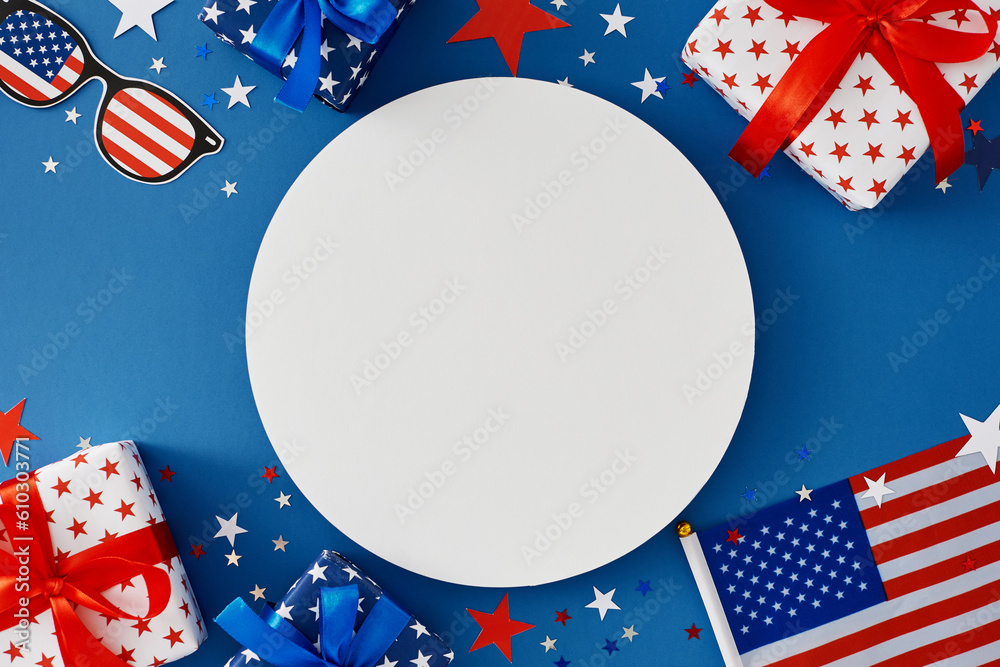 Obraz premium Idea for a Fourth of July party. Top view flat lay of patriotic gift boxes, fourth of July accessories, event confetti on blue background with blank circle for text