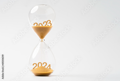 Sand inside of hourglass of change year from 2023 to 2024 for countdown of merry Christmas.and happy new year concept.