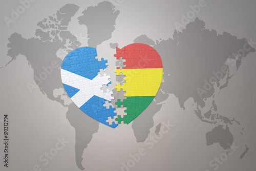 puzzle heart with the national flag of bolivia and scotland on a world map background.Concept.